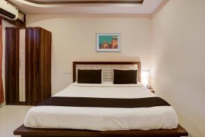a bedroom with a large bed in a room at Super Hotel O Vaishnavi Inn in Hyderabad