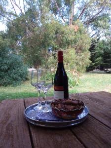 eine Flasche Wein, ein Glas und eine Schale Nüsse in der Unterkunft Hobreid Park in Woodend