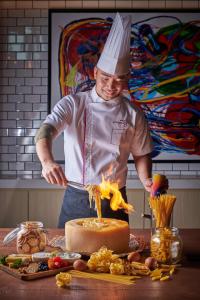 a man in a chefs hat standing in front of a cake at Moxy Putrajaya in Putrajaya