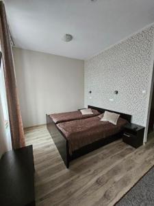 a bedroom with a bed and a wooden floor at Apart in Radomsko
