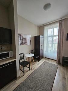 uma sala de estar com uma mesa e cadeiras e uma janela em Apart em Radomsko
