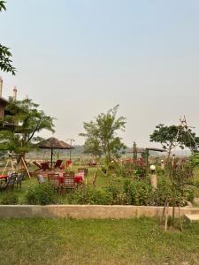 a garden with tables and chairs in the grass at Hotel Riverside with Swimming pool in Sauraha