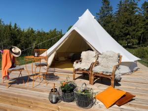 ein weißes Zelt mit 2 Stühlen und einem Tisch in der Unterkunft Pädaste Aerga Sunrise Glamping in Pädaste