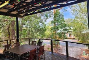 una terrazza con tavolo, sedie e vista di EUROLIE ON HIGH at Kingfisher Bay Fraser Island a Kingfisher Bay