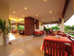 a restaurant with a table and chairs in a room at Baan Chay Namm Resort in Bangkok