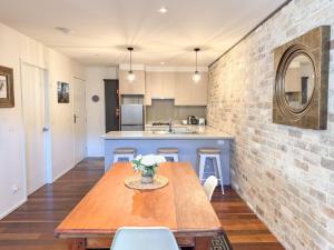 a kitchen with a wooden table and a brick wall at Iron Bark Chalet in Crackenback