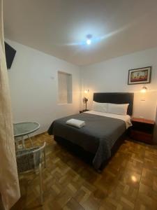 a bedroom with a bed and a table and a chair at El Capricho Paracas in Paracas