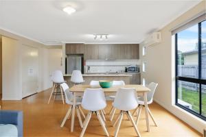 Una cocina y un comedor con mesa y sillas. en Villa Blue, en Cowes