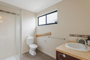 Un baño con inodoro, lavabo y ventana. en Villa Blue, en Cowes 9 fotos más