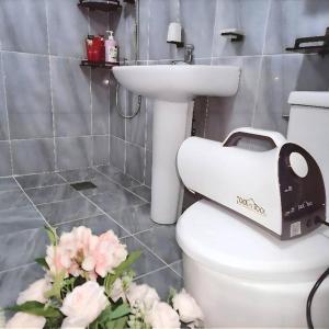 een badkamer met een toilet, een wastafel en bloemen bij Daejeon St Entire House in Daejeon