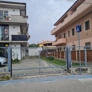 una valla frente a un edificio con aparcamiento en Gate 25 en San Giovanni Teatino