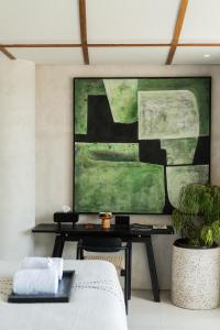 een woonkamer met een tafel en een schilderij aan de muur bij Oculus Bali in Kintamani