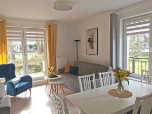 sala de estar con sofá y mesa en Apartamenty Wybrzeże Laguna en Ustronie Morskie
