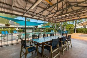 a patio with a table and chairs and a pool at Cable Beachside Apartments in Broome +26 photos