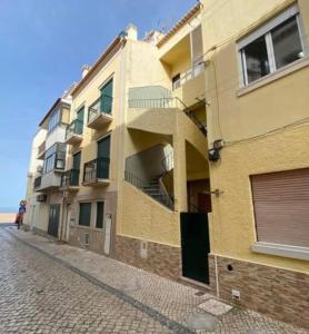 a building with balconies on the side of a street at Casa Carvalho Laranjo in Nazaré