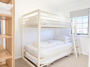 a bunk bed room with a white bunk bed at Karoonda Lodge in Jindabyne