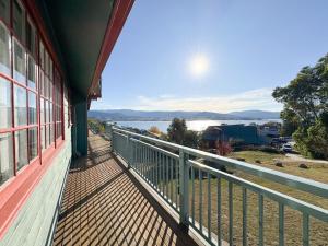 a balcony of a house with a view of the water at Karoonda Lodge in Jindabyne