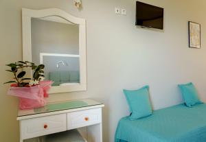 - une chambre avec un lit, un miroir et une commode dans l'établissement Diona Studios, à Lourdhata