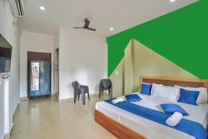 a bedroom with a large bed with a green wall at Little Beach Home Stay at Calangute in Calangute