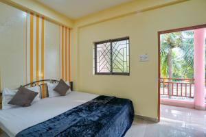 a bedroom with a bed and a large window at Little Beach Home Stay at Calangute in Calangute