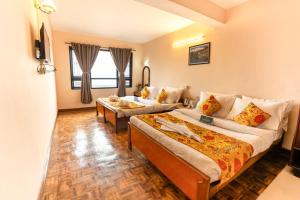 a hotel room with two beds and a couch at Muscatel Fairmont – 100 Mts from Mall Road in Darjeeling