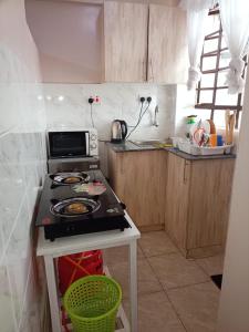una cocina con estufa y encimera en King's homes, en Nairobi