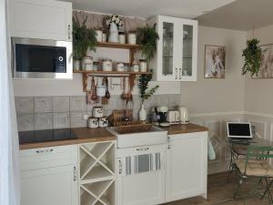 a kitchen with white cabinets and a counter top at Le studio de Chloé en Provence in Fourques