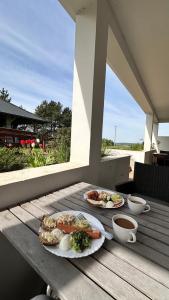 dwie talerze jedzenia na drewnianym stole na ganku w obiekcie Cisowe Sioło w mieście Jeleniewo