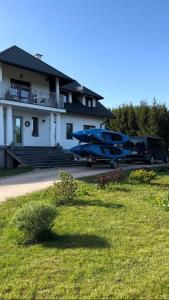 two blue boats parked in front of a house at Cisowe Sioło in Jeleniewo