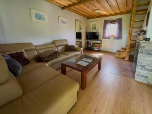 a living room with a couch and a coffee table at Domek nad Jeziorem in Ryn