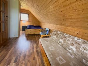 a log cabin with a bed in a room at Domek nad Jeziorem in Ryn