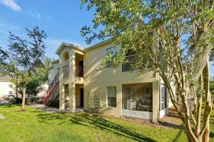 a white house with a tree in front of it at Spacious Condo W/ Pool,Gym near Disney & Seaworld in Kissimmee