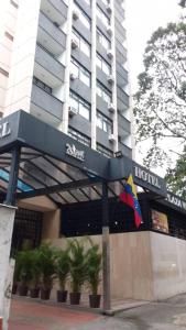 a hotel with a flag in front of a building at Hotel Plaza Venezuela in Caracas