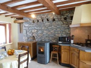 cocina con fogones y pared de piedra en gîte Le cheval ardennais en Gouvy
