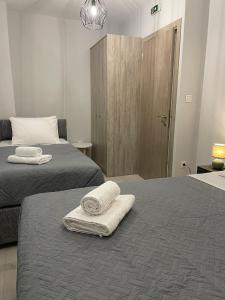 two beds in a room with two towels on them at TERRA HOMERICA in Chios