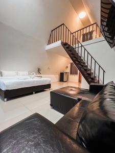 a living room with a bed and a staircase at บ้านสวนพระคุณพ่อ-แม่ in Udon Thani