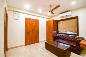 a living room with a couch and a ceiling fan at FabHotel Dreamworld Residency - Near bisarjan ghat in Kolkata +22 photos