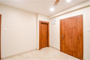 an empty room with two wooden doors in it at FabHotel Dream World Residency in Kolkata