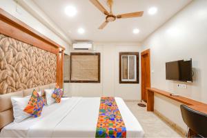 a bedroom with a bed and a flat screen tv at FabHotel Dream World Residency in Kolkata