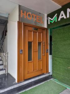 une porte en bois d'un hôtel avec un panneau au-dessus. dans l'établissement The Robin- A Boutique Hotel, à Jaipur