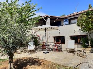 a patio with a table and an umbrella and chairs at LA BOHÊME by K6 Conciergerie Villas in Cassis