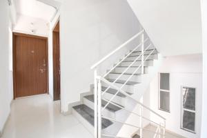 a white staircase in a house with a wooden door at FabHotel Happy Stay In in Hinjewadi