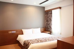 Schlafzimmer mit einem Bett und einem Fenster in der Unterkunft hotel VR osaka in Osaka