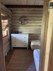 ein Schlafzimmer mit einem Bett und einer Kommode in einer Blockhütte in der Unterkunft Sepasaun in Joaveski