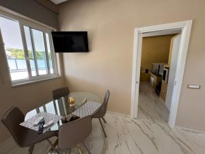 a dining room with a glass table and a television at AETERNA SUITES SPA Apartment in Terracina