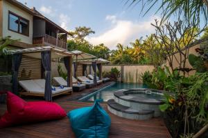 a backyard with a swimming pool and a house at The Compass Rose Ubud in Ubud