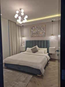 ein Schlafzimmer mit einem großen Bett und einem Kronleuchter in der Unterkunft Luxury Romantic Sea View Apartment. in Manama