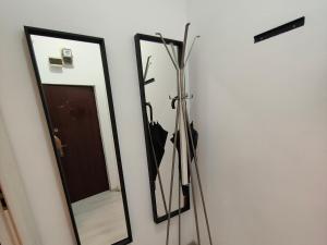 Un espejo y algunos paraguas en una pared. en Downtown Studio, en Bucarest 15 fotos más