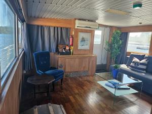 M/S Furusund في Furusund: غرفة معيشة مع كرسي أزرق وأريكة