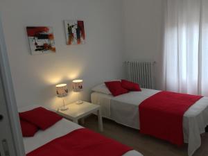 una camera con due letti con lenzuola rosse e bianche di Ostuni nuova casa vacanze a Ostuni